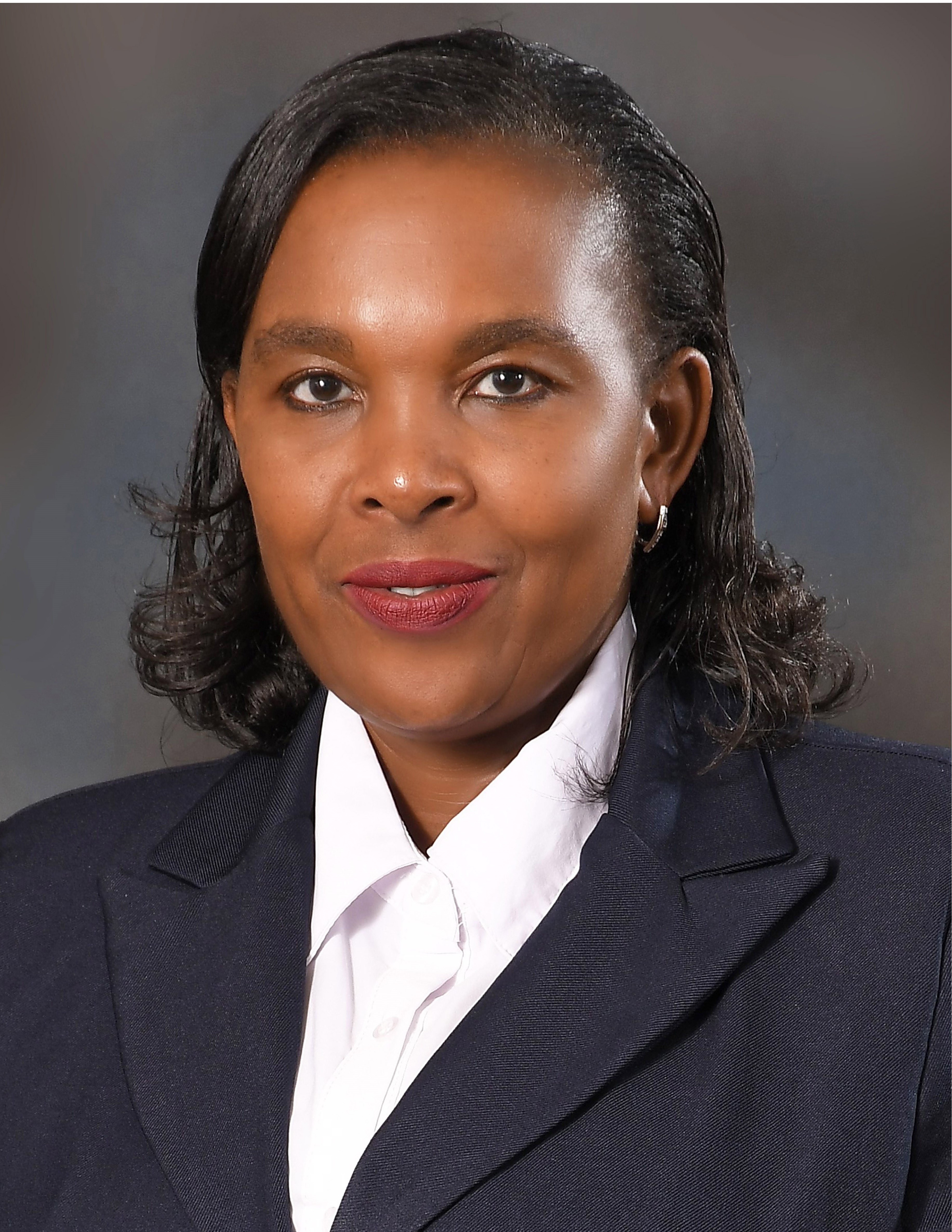 Women wearing a suit and smiling to the camera